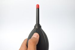 Hand holding dust remover for glasses