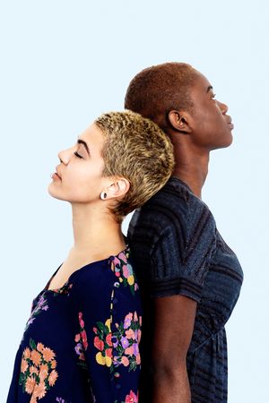 Two women standing back to back in studio