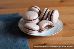 Delicious chocolate macarons on wooden table with blue napkin 5wPQ14