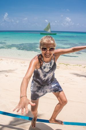 Adult cheerful woman on beach near water