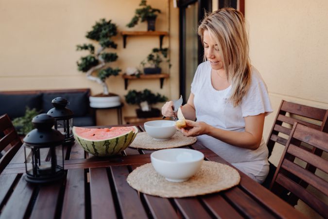 Pregnant woman cutting banana to bowl