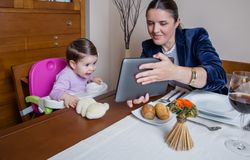 Businesswoman mother and baby girl looking tablet