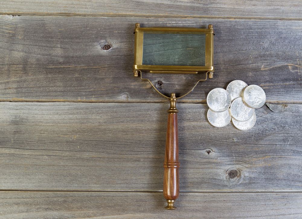 Coin collecting with magnifying glass and coins