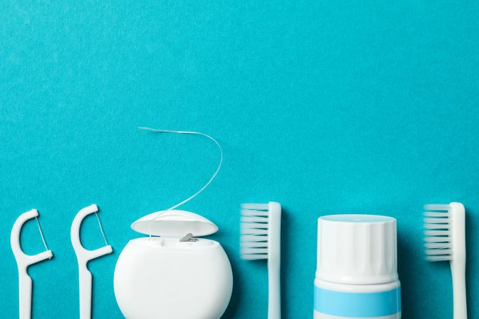 Tools for dental care on turquoise background, space for text