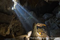 Sunrays entering the immense Phu Kham Cave, famous for its reclining golden Buddha, Laos 47Pvgb
