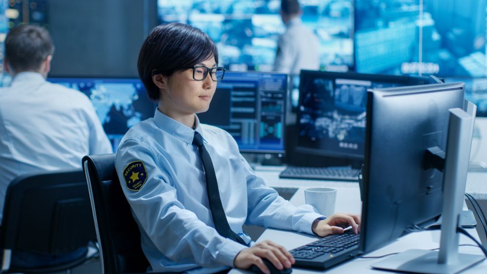 In the Security Command Center Officer at His Workstation Monitors Multiple Screens for Unlawful Infiltration.