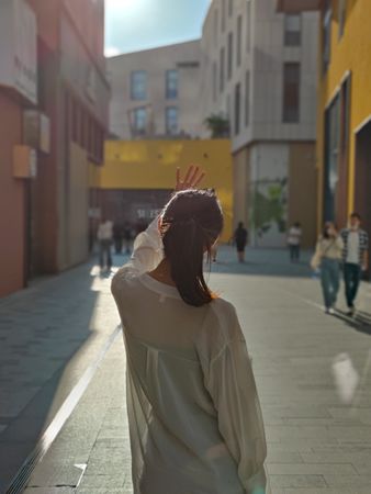 Back view of young woman blocking the sun