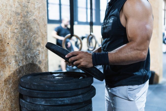 Anonymous sportsman near barbell weight set