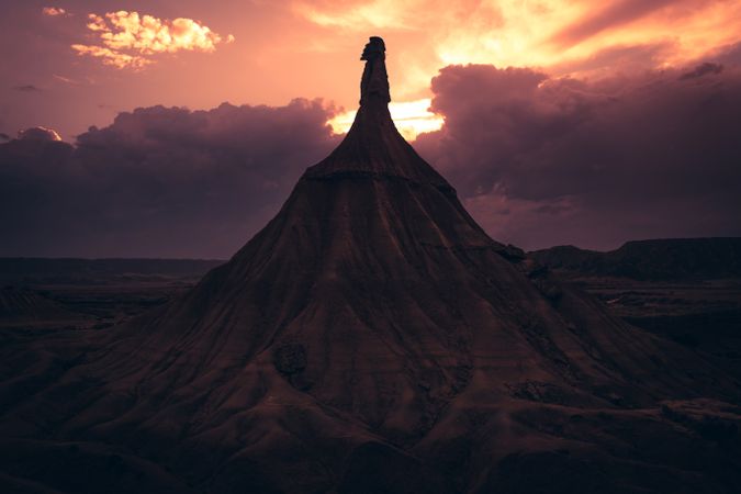 Stone peak in desert against evening sky