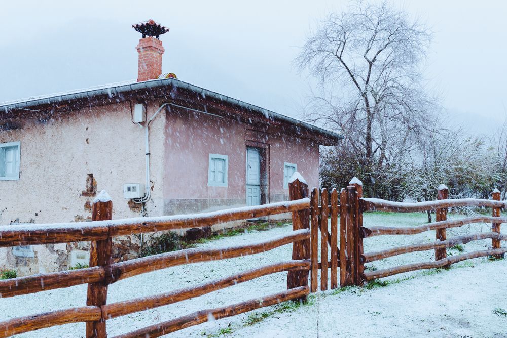 Old building and wooden fence in winter