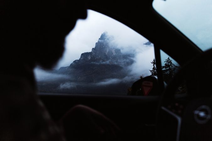 Powerful mountains and cloudy sky view from window of car