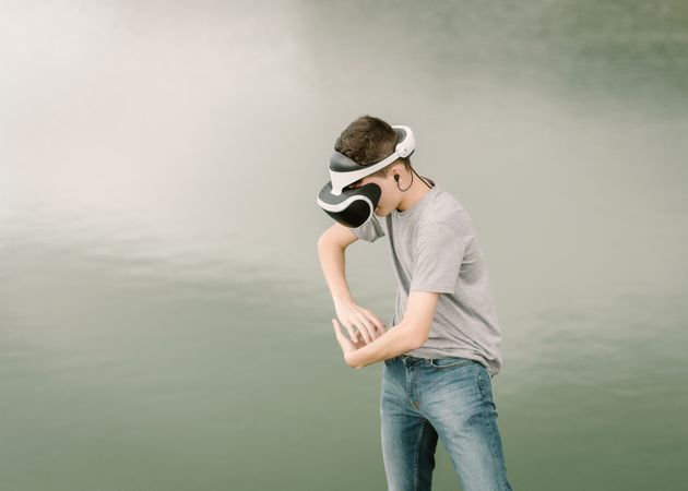 Young teenager with virtual reality glasses outdoors