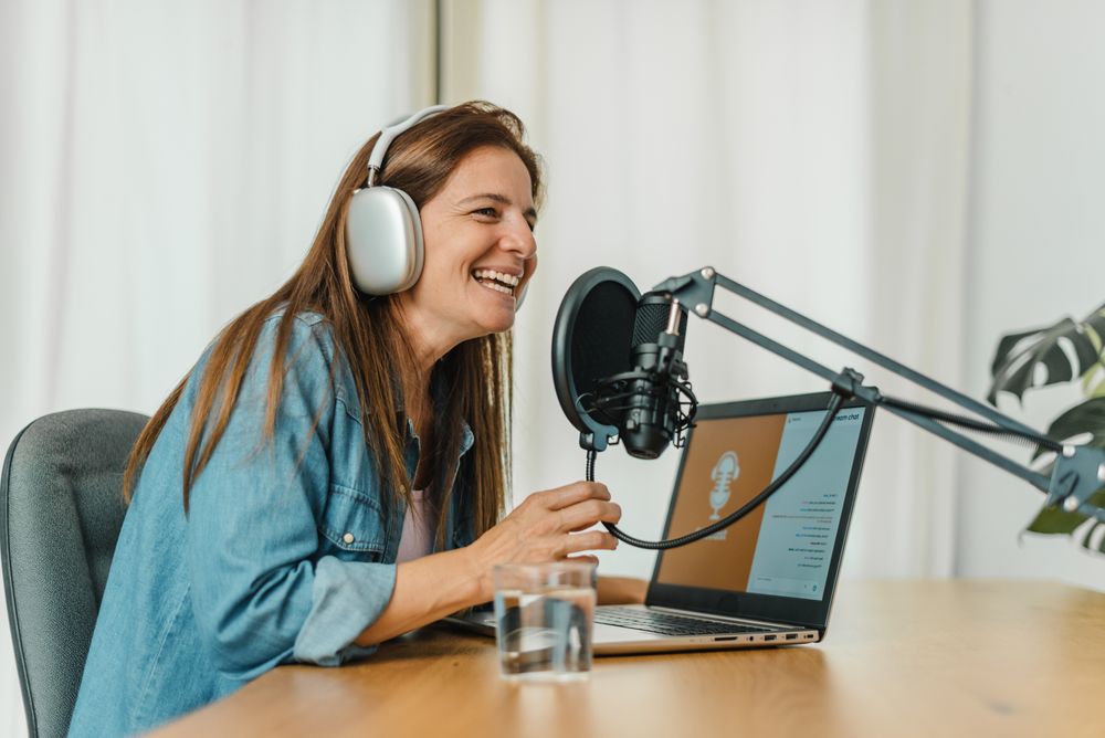 Happy woman recording podcast and speaking in mic