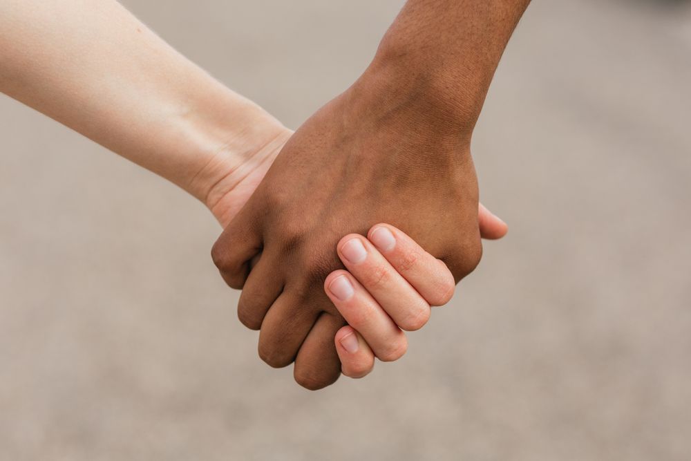 Multiethnic best friends holding hands tenderly