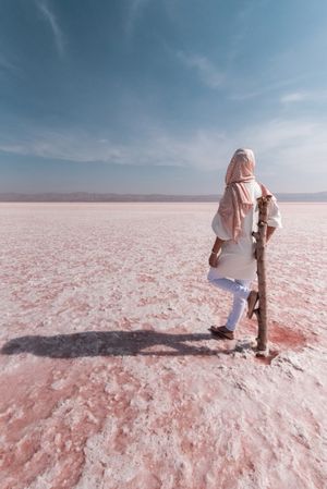 Thoughtful relaxed tourist enjoying unusual scenery of pink salt lake