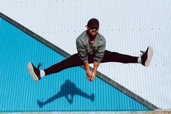Trendy male flipping and jumping on street