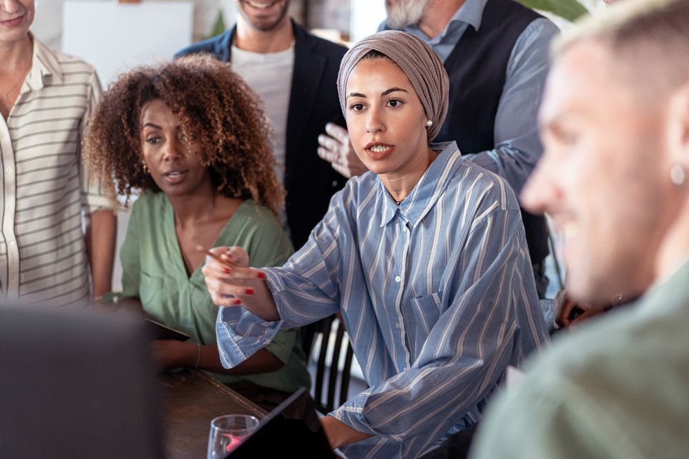 Multi-ethnic group of colleagues problem solving around the computer screen