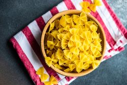 Uncooked bowl of bow tie pasta with copy space