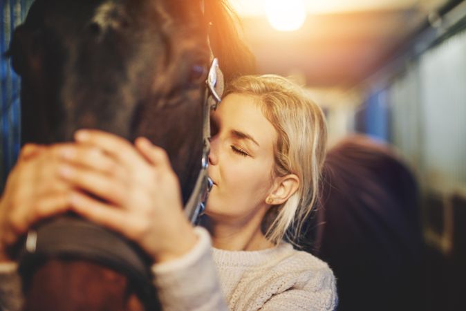 Caring female adult showing affection to her horse companion