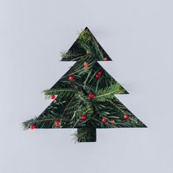 Holiday tree cut out of paper with pine background