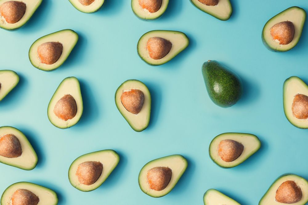 Avocado halves pattern on a pastel blue background