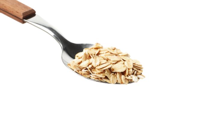 Spoon with oatmeal flakes isolated on plain background