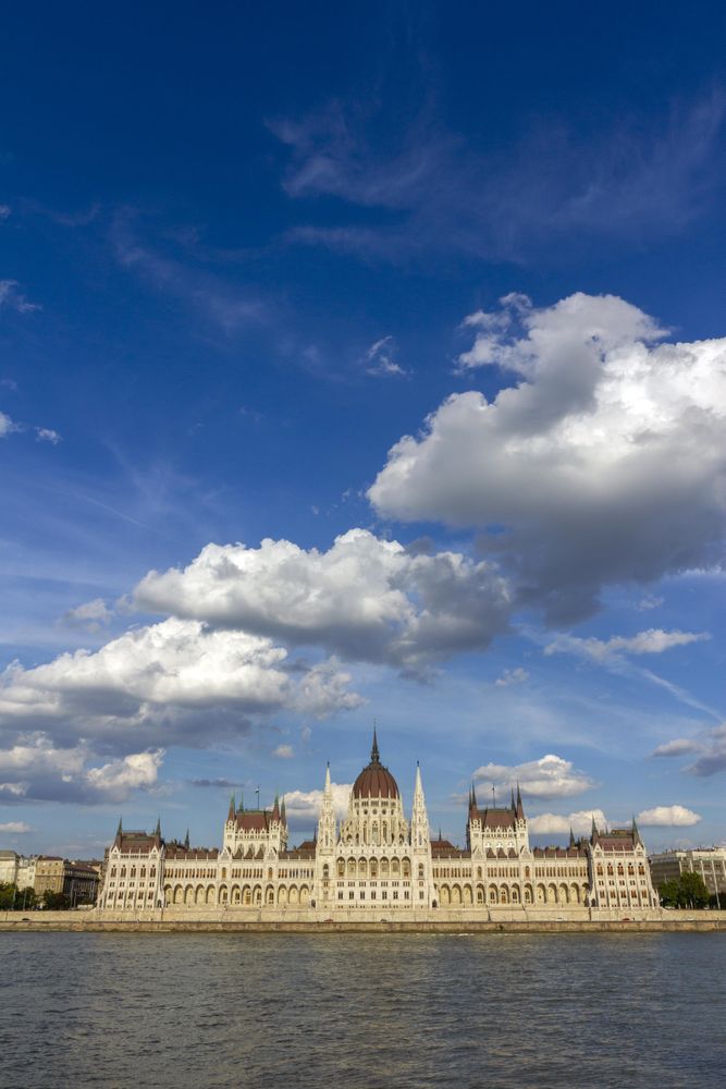 Blue sky and fluffy clouds over Hungarian Parliament building, vertical