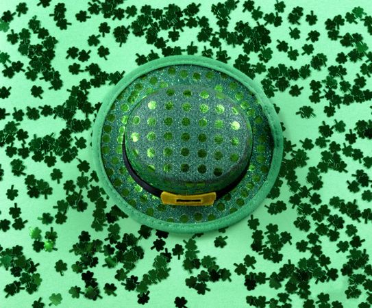 St Patrick’s Day with shamrocks and shiny hat on green background