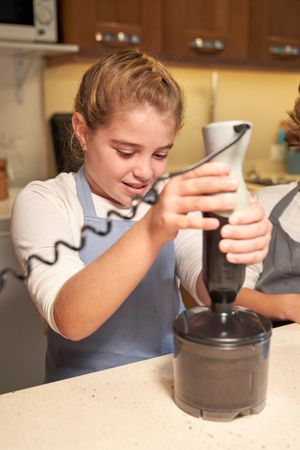 Girl grinding ingredients in blender