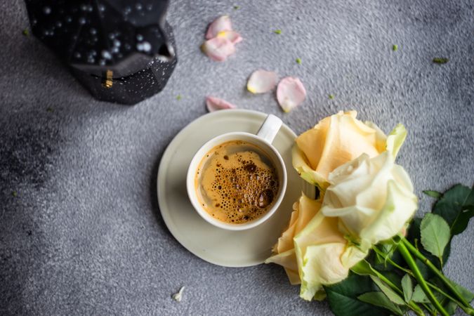 Top view of floral card on concrete background with cup of coffee