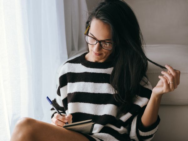 Charming woman writing in notepad