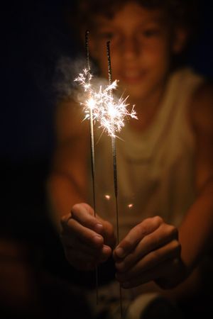 Boy with bright glowing Bengal lights