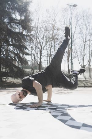 Man dancing break dance in park