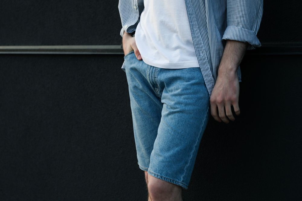 Young man stands against wall. Space for text