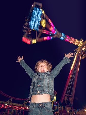 Astonished boy near illuminated attraction