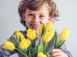 Cheerful boy with bunch of tulips