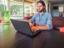 Focused man using computer in apartment
