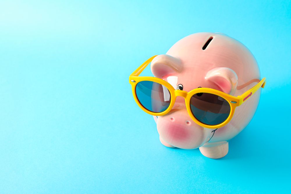 Happy piggy bank with sunglasses on color background, space for text. Finance, saving money