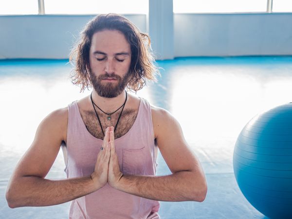 Male meditating in spacious room