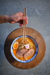 Unrecognizable person enjoying noodle soup in restaurant