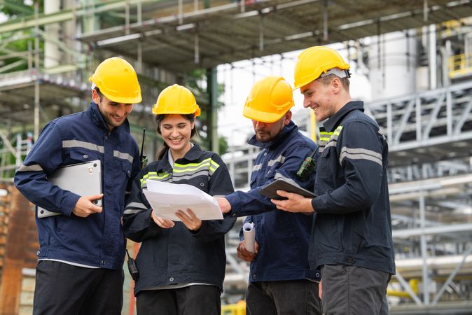Group of engineer workers checking project at petrochemical factory or refinery oil plant industrial.