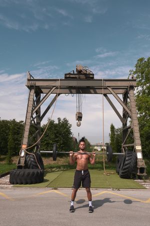 Black guy with barbell in outdoor gym