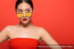 Stylish female model wearing sunglasses in red studio 5QVNe4