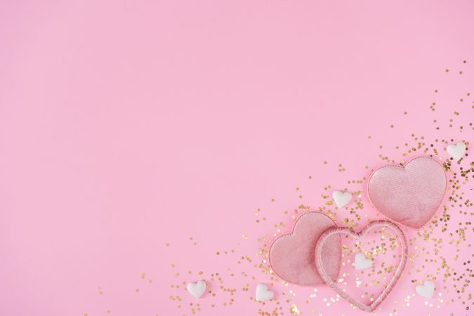 Pink hearts and gold glitter on pink background