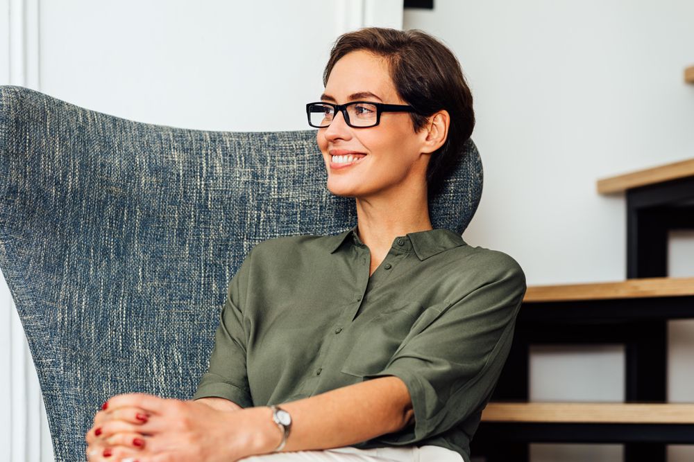 Smiling woman sitting in an armchair near the stairs
