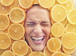 Discontent woman immersed in pile of cut oranges
