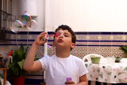 Boy blowing bubbles on terrace