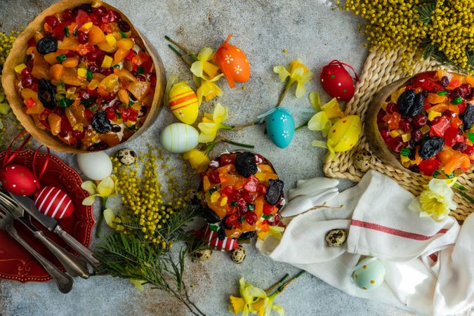 Top view of Easter food concept with fruit cakes, Easter eggs and spring flowers