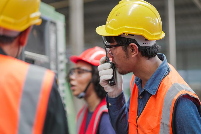 Asian male engineer using walkie talkie in factory
