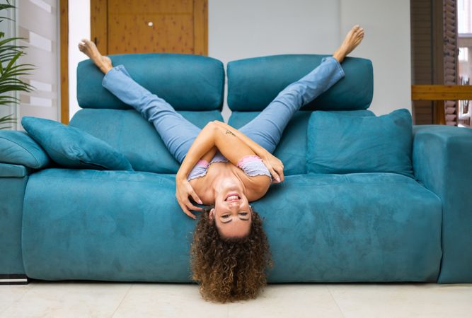 Woman stretching and lying back on sofa